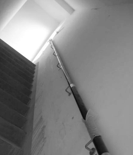 剪刀楼梯的扶手放在梯井中间砌的剪刀楼梯隔墙那面吗?