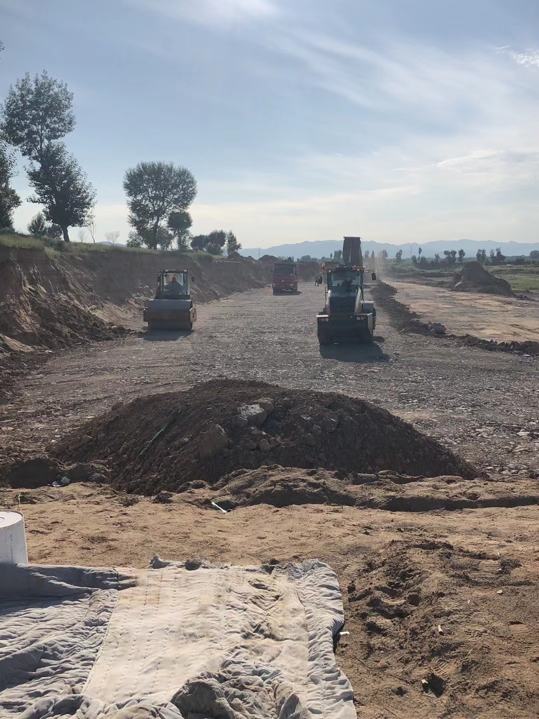 现场实际情况为河道需要碾压分层回填山皮石套取那项定额呢